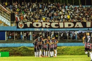 Imagem jogadores abraçados em frente a torcida