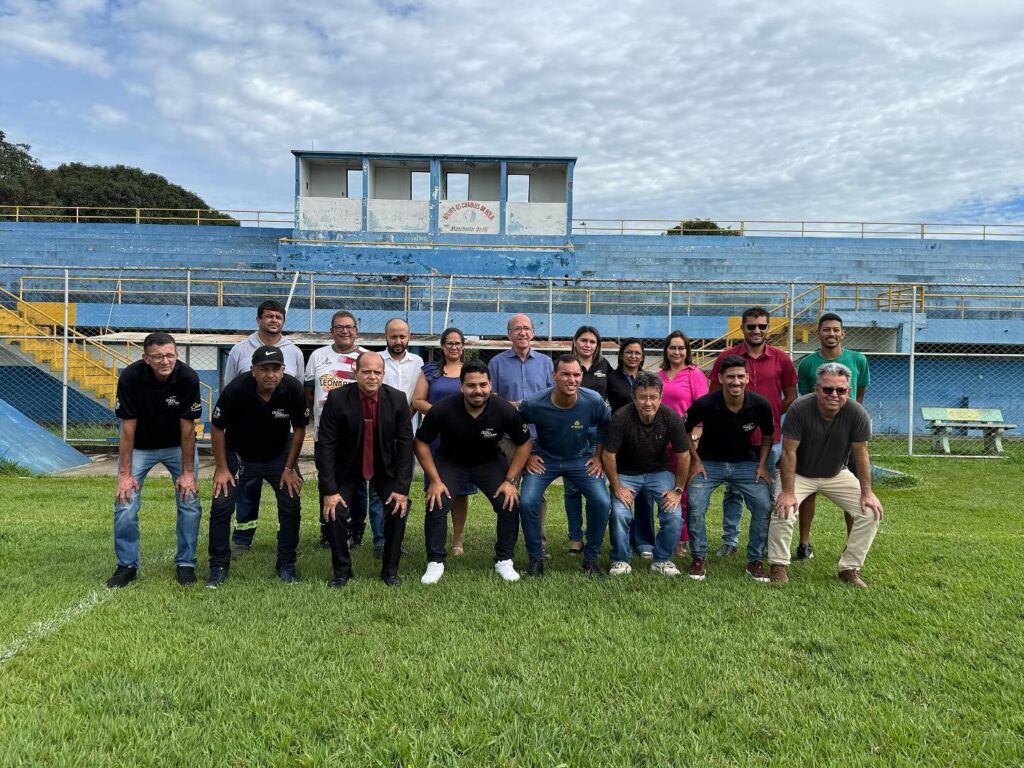 Imagem pessoas perfiladas no campo de futebol