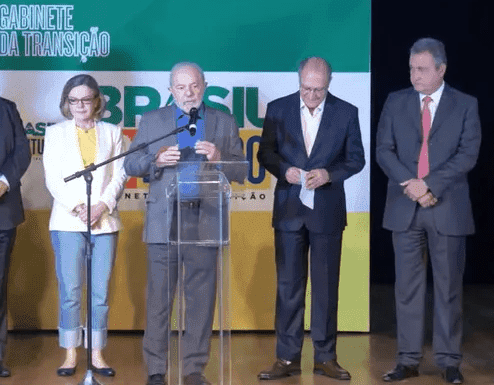 Imagem homens de terno falando microfone