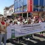 Imagem Caminhada Cruzada Pela Dignidade, jovens segurando uma faixa vão a frente