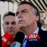 Imagem Jair Bolsonaro concedendo entrevista, microfones estão em frente Bolsonaro