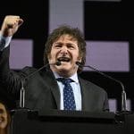 Imagem Xavier Milei presidente da Argentina, com o braço direito erguido e roto fransido