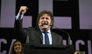 Imagem Xavier Milei presidente da Argentina, com o braço direito erguido e roto fransido