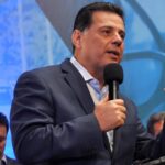 Imagem Marconi Perillo falando, ele segura o microfone