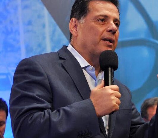 Imagem Marconi Perillo falando, ele segura o microfone