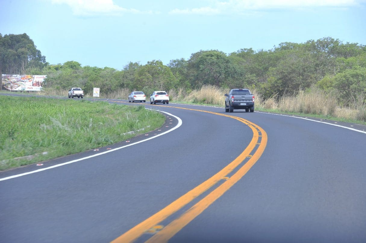 Imagem Rodovia, carros aparecem em uma curva da pista