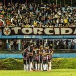 Imagem jogadores abraçados em frente a torcida