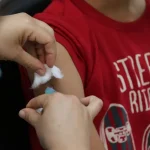 Imagem criança recebendo vacina no braço