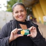 Imagem mulher segurando cartão do Aluguel Social