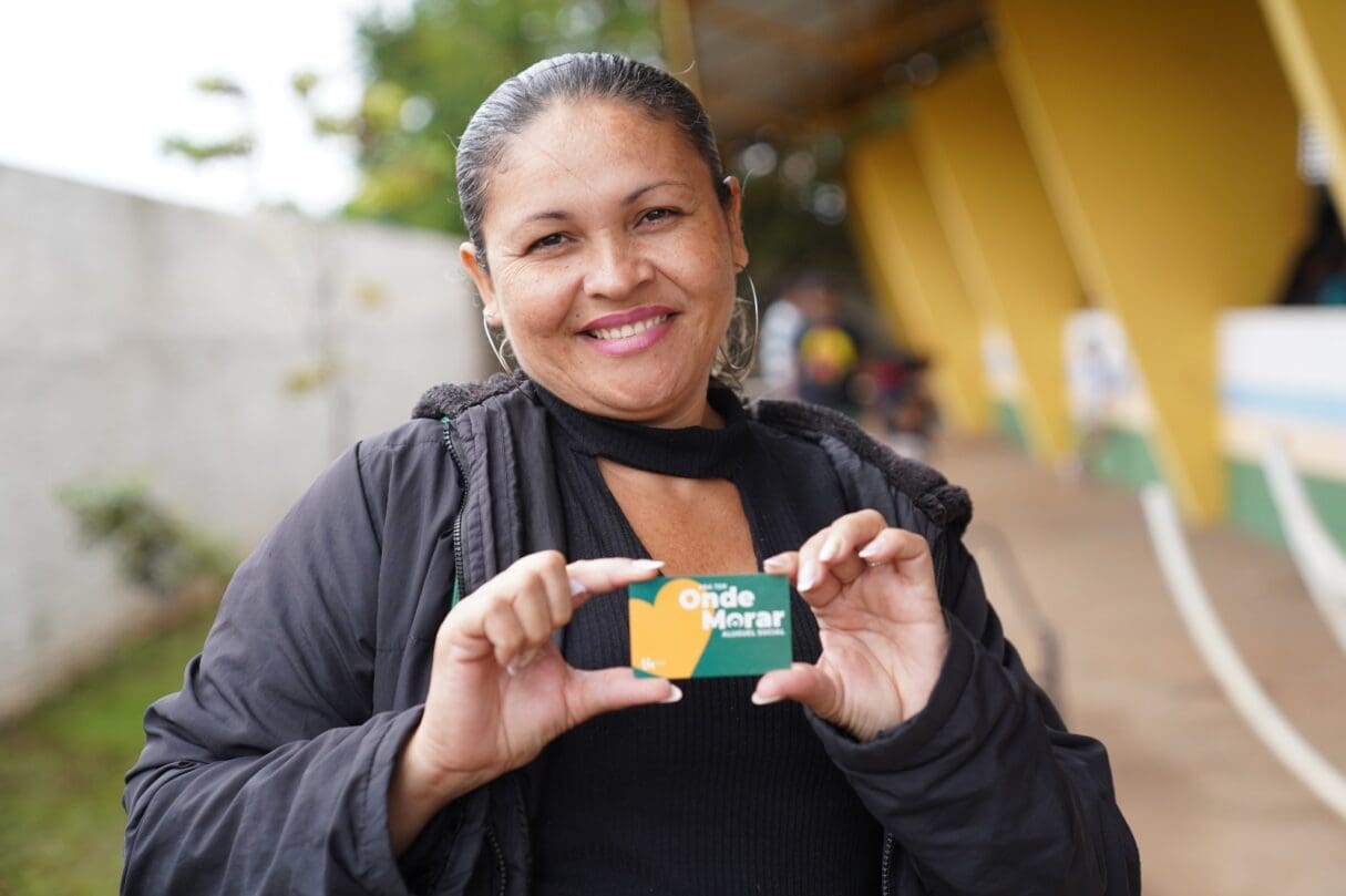 Imagem mulher segurando cartão do Aluguel Social
