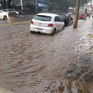 Imagem chuva no asfalto próximo de carros estacionados no centro de Anápolis