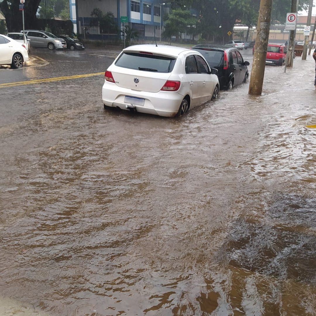 Imagem chuva no asfalto próximo de carros estacionados no centro de Anápolis