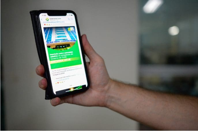 Imagem pessoa segurando celular na mão com o aplicativo do governo