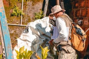 Imagem agente de endemia mexendo em uma lona branca buscando foco do mosquito transmissor da Dengue