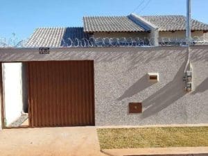 Imagem de casa onde mostra o portão marron com muro branco