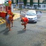 Imagem bombeiro tentando reanimar criança engasgada duas mulheres e um homem estão ao lado