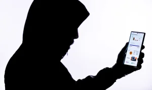 Imagem sobra de criminoso segurando celular