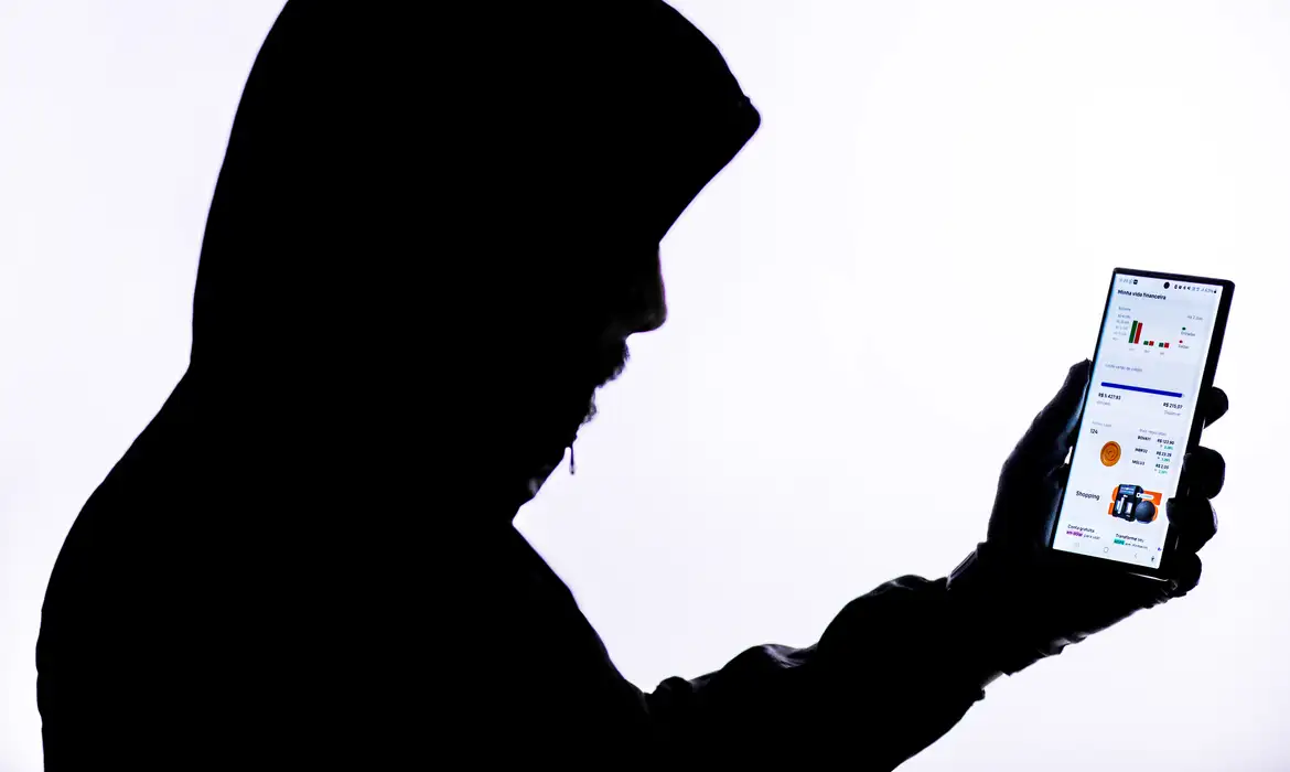 Imagem sobra de criminoso segurando celular