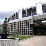 A imagem mostra um prédio branco, com uma fachada frontal que diz "Palácio da Justiça" em letras amarelas.