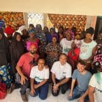 Imagem pessoas pousando para foto Dom Dilmo está de joelhos abaixo na imagem