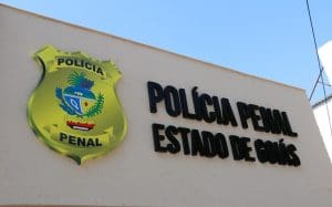Uma fachada bege diz "Polícia Penal Estado de Goiás".