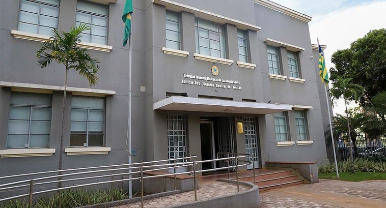 Um prédio cinza é visto pela frente. Letras pequenas na fachada dizem "Tribunal Regional Eleitoral do Governo de Goiás".