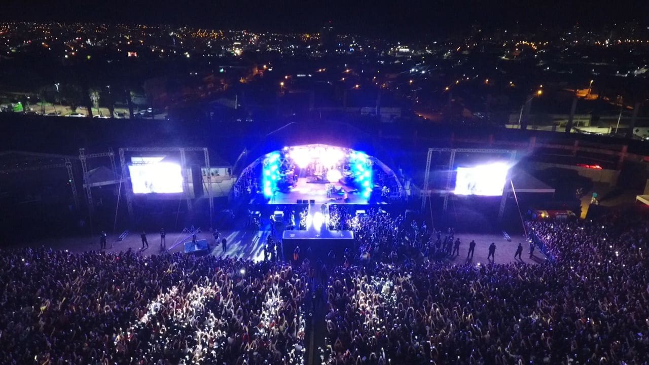 Um show noturno está acontecendo. As luzes do palco são azuis.