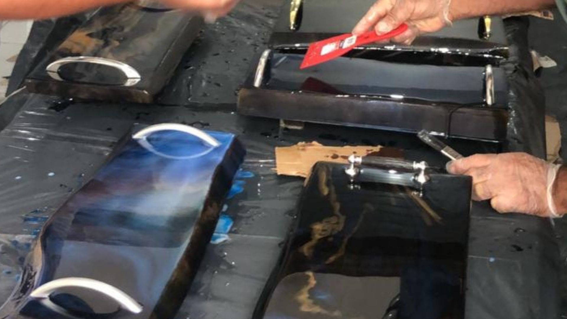 Mãos mexem em uma superfície com resina.