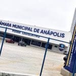 Fachada da Câmara Municipal de Anápolis. Também é possível ver o estacionamento e a grade que cerca o local.