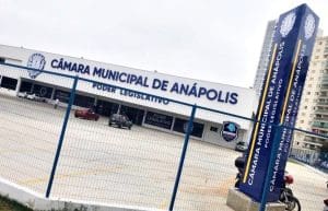 Fachada da Câmara Municipal de Anápolis. Também é possível ver o estacionamento e a grade que cerca o local.