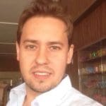 Christiano Mamedio sorri para a câmera enquanto tira uma selfie. Ele é um homem branco de cabelos claros.