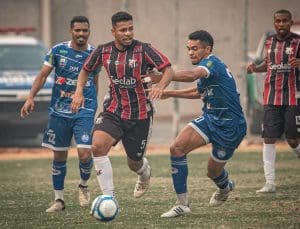 Kevyn, jogador do Anápolis, conduz a bola enquanto dois jogadores do Iguatu tentam tomá-la.