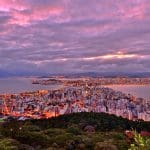 A cidade de Florianópolis é vista de cima durante o pôr do sol. Ao fundo, a Baía do Morro da Cruz.