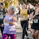 Foto de uma edição passada do Circuito Anapolino de Corrida de Rua. Diversas pessoas estão correndo vestindo o número de peito.