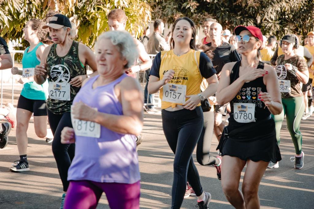 Foto de uma edição passada do Circuito Anapolino de Corrida de Rua. Diversas pessoas estão correndo vestindo o número de peito.