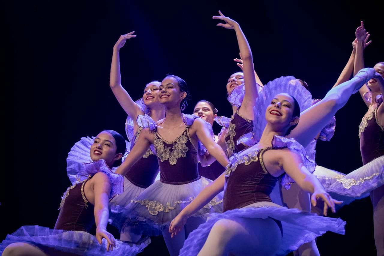 Dançarinas de balé encerram uma apresentação, na pose final da coreografia.