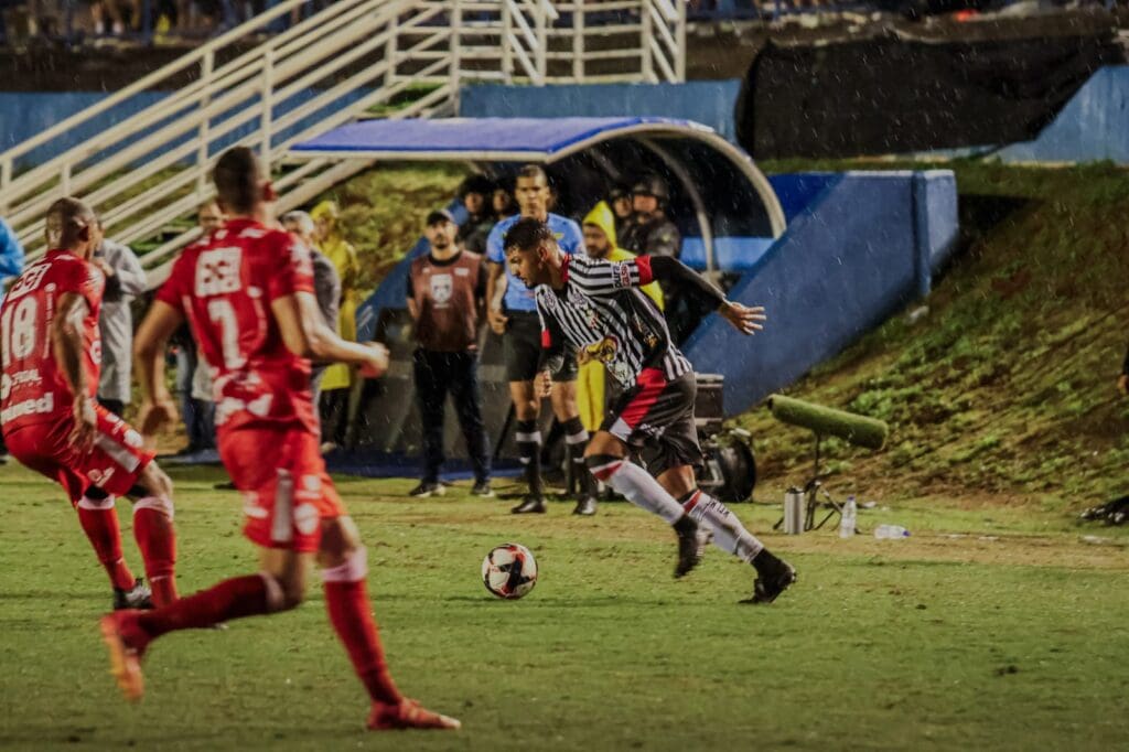 Imagem jogador do Anápolis com a bola cercado por jogadores do Vila Nova