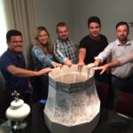 Imagem pessoas com a mão em uma maquete de sino