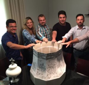 Imagem pessoas com a mão em uma maquete de sino