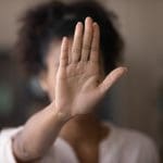 Imagem de mulher com a mão na frente do rosto