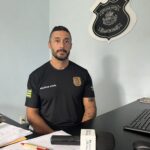 Imagem delegado Manoel Vanderci sentado na mesa da delegacia