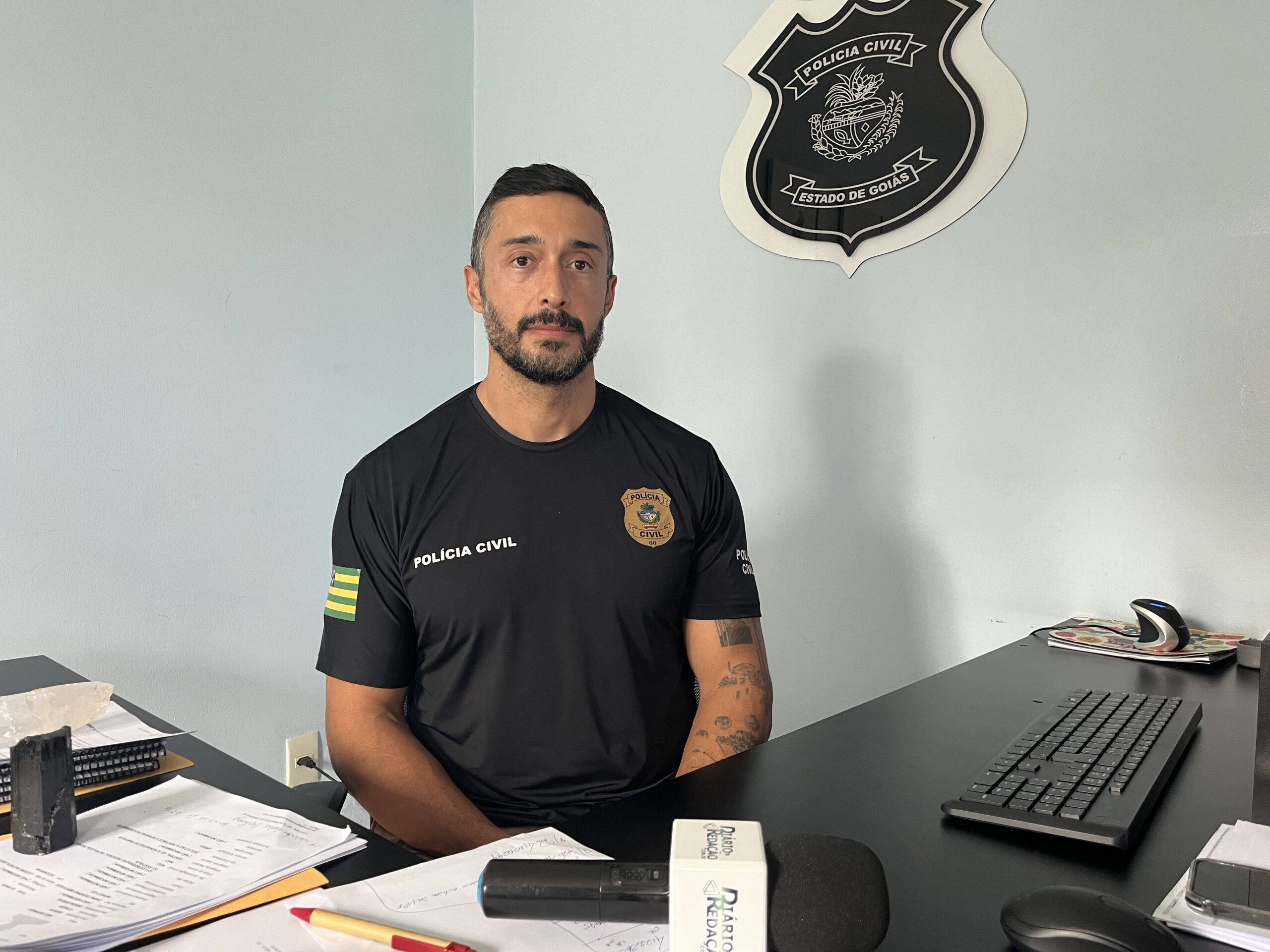 Imagem delegado Manoel Vanderci sentado na mesa da delegacia