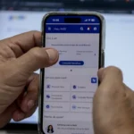 Imagem mão segurando celular com o aplicativo Meu INSS aberto