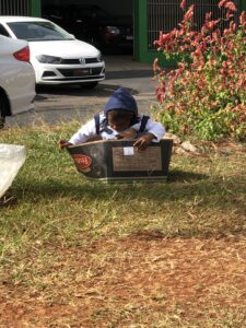 Imagem Criança Venezuelana dentro de uma caixa de papelão no canteiro central de uma rua em Anápolis