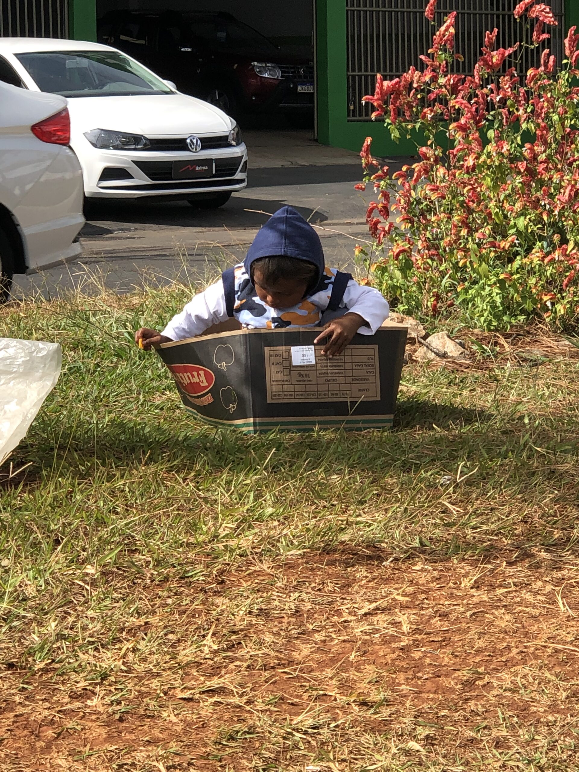Imagem Criança Venezuelana dentro de uma caixa de papelão no canteiro central de uma rua em Anápolis
