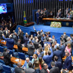 Imagem Senado Federal do Brasil, senadores aparecem em pé durante sessão