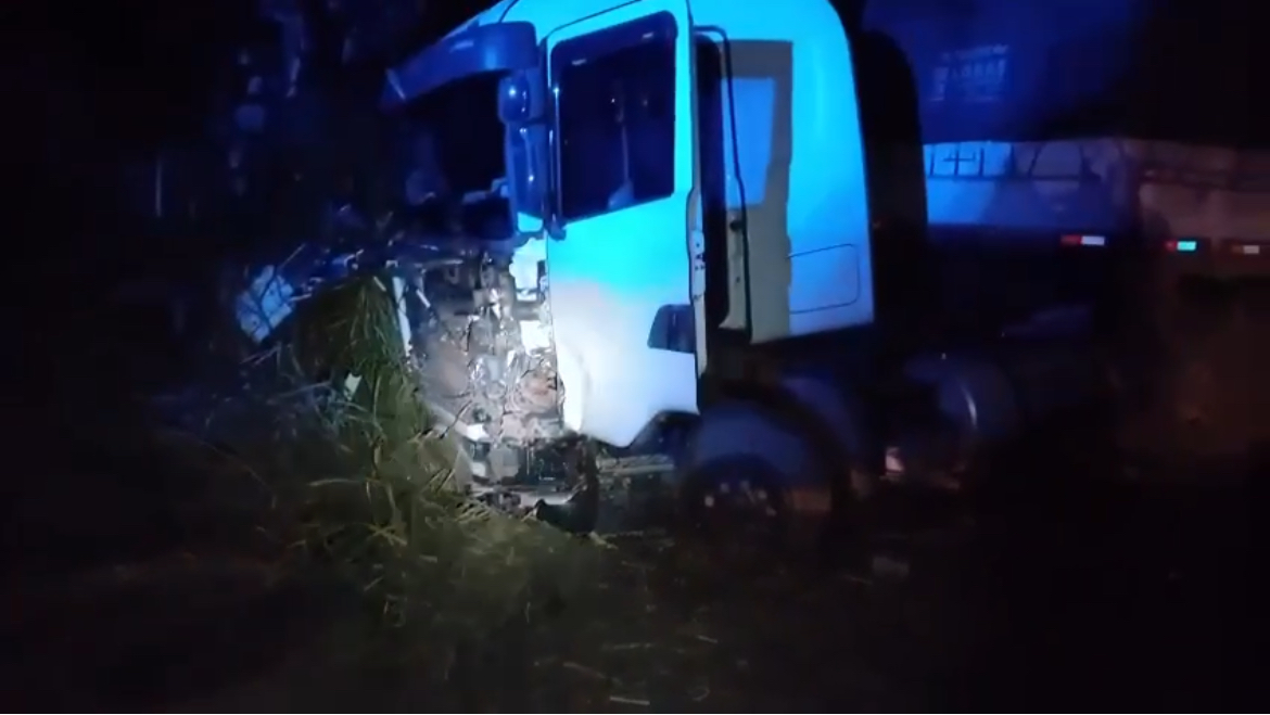 Imagem caminhão que colidiu na rodovia, está escuro e o caminhão está danificado