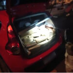 Imagem carro vermelho com o porta malas lotado com tabletes de maconha