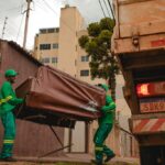 Imagem trabalhadores recolhendo sofá velho no caminhão da Prefeitura.