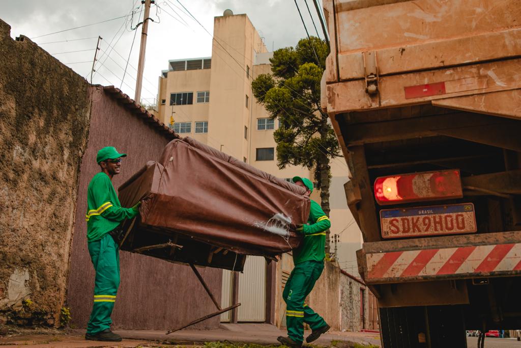 Imagem trabalhadores recolhendo sofá velho no caminhão da Prefeitura.